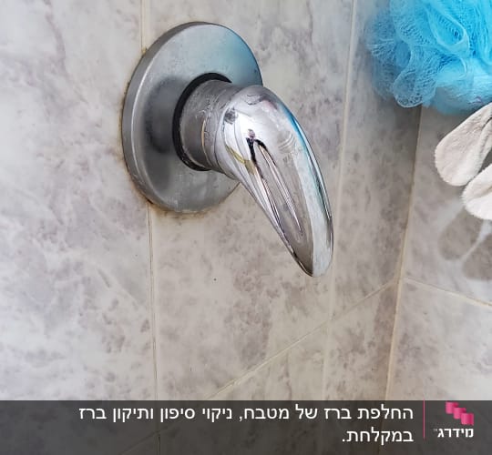 ברז כרום מותקן על קיר אריחים במקלחת